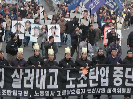 집회 참석자들이 마산 거리를 행진하고 있다. 참석자들은 만장과 대형 영정을 수십개 들고 나왔다. 